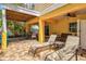 Covered patio space with outdoor dining table, lounge chairs, and brick flooring at 145 50Th St, Holmes Beach, FL 34217