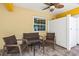 Covered outdoor living space with comfortable seating and ceiling fan at 145 50Th St, Holmes Beach, FL 34217