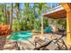 Picturesque backyard with sparkling pool, lush landscaping, sun deck, and comfortable lounge chairs at 145 50Th St, Holmes Beach, FL 34217