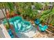 Aerial view of a private kidney-shaped pool surrounded by lush landscaping with brick-paver accents at 145 50Th St, Holmes Beach, FL 34217