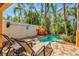 Private pool area featuring lounge chairs, tropical landscaping, and a white privacy fence at 145 50Th St, Holmes Beach, FL 34217