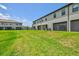 Lush backyard with green grass, featuring exterior view of the house with a screened-in patio at 14835 Lyla Ter, Bradenton, FL 34211