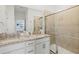 A bright bathroom featuring double sinks, a granite counter, and a glass-enclosed shower at 14835 Lyla Ter, Bradenton, FL 34211