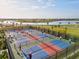 Aerial view of pickleball courts with residents playing, all surrounded by lush landscaping and scenic water views at 14835 Lyla Ter, Bradenton, FL 34211