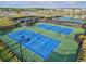 Aerial view of pristine blue tennis courts showcasing the community's recreational amenities and lush landscaping at 14835 Lyla Ter, Bradenton, FL 34211
