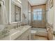 Bathroom with illuminated mirror, neutral tiling, tub and quartz countertop at 1864 Goldenrod St, Sarasota, FL 34239