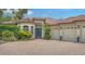 Beautiful exterior with a brick driveway, barrel tile roof, lush landscaping and three-car garage at 1864 Goldenrod St, Sarasota, FL 34239