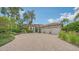 Beautiful exterior with a brick driveway, barrel tile roof, lush landscaping and three-car garage at 1864 Goldenrod St, Sarasota, FL 34239