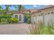 Beautiful exterior with a brick driveway, barrel tile roof, lush landscaping and three-car garage at 1864 Goldenrod St, Sarasota, FL 34239