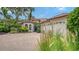 Beautiful exterior with a brick driveway, barrel tile roof, lush landscaping and three-car garage at 1864 Goldenrod St, Sarasota, FL 34239