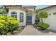 Elegant front entry with brick pathway, blue double doors, side windows and mature, manicured landscaping at 1864 Goldenrod St, Sarasota, FL 34239