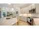 Open-concept kitchen features marble counters, stainless appliances, white cabinets and travertine floors at 1864 Goldenrod St, Sarasota, FL 34239
