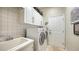 Efficient laundry room with white cabinets, a utility sink, and a modern washer and dryer at 1864 Goldenrod St, Sarasota, FL 34239