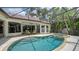 Sparkling pool and spa surrounded by a screened enclosure and lush tropical landscaping at 1864 Goldenrod St, Sarasota, FL 34239