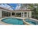 Sparkling pool and spa surrounded by a screened enclosure and lush tropical landscaping at 1864 Goldenrod St, Sarasota, FL 34239
