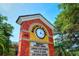 A street-side sign for Morton's Plaza features a clock and business listings at 1864 Goldenrod St, Sarasota, FL 34239