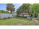 Lush backyard with neatly manicured lawn, complemented by colorful kayaks and tropical landscaping at 2420 Webber St, Sarasota, FL 34239