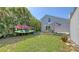 Landscaped backyard featuring a patio, lush lawn, and colorful kayaks, perfect for relaxation and recreation at 2420 Webber St, Sarasota, FL 34239