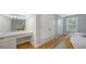 Bright bathroom with a makeup vanity and lighting, hardwood floors and white closets at 2420 Webber St, Sarasota, FL 34239