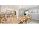 Bright dining room with long wood table and stylish chandelier next to the kitchen at 2420 Webber St, Sarasota, FL 34239