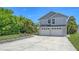 Two-story home with an attached garage, surrounded by tropical landscaping and a well-manicured lawn at 2420 Webber St, Sarasota, FL 34239