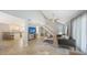 Open living room with tile flooring, airy decor, stairs to upper level and open concept kitchen at 2420 Webber St, Sarasota, FL 34239