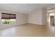 Bright living room with tiled floor, ceiling fan, and a window featuring a natural, woven shade at 2662 6Th E Ct, Ellenton, FL 34222