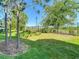 Enjoy the backyard oasis with mature landscaping, a well-maintained lawn, and a black metal fence at 30073 Southwell Ln, Wesley Chapel, FL 33543