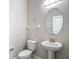 Powder room featuring a pedestal sink, oval mirror, and modern fixtures at 30073 Southwell Ln, Wesley Chapel, FL 33543