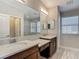 Bright bathroom with double sinks, marble countertops, tile flooring, and a large mirror at 30073 Southwell Ln, Wesley Chapel, FL 33543