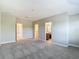 Spacious bedroom with neutral walls, carpet flooring, and two open doorways to other rooms at 30073 Southwell Ln, Wesley Chapel, FL 33543