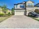 Tan and white townhome with brick paved driveway and two-car garage at 30073 Southwell Ln, Wesley Chapel, FL 33543