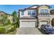 Tan and white townhome with a brick paved driveway and attached two-car garage at 30073 Southwell Ln, Wesley Chapel, FL 33543