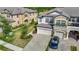 Aerial view of a townhome with brick-paved driveway and two-car garage, beautifully landscaped at 30073 Southwell Ln, Wesley Chapel, FL 33543