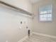 Laundry room with window for ventilation and wire shelving for storage at 30073 Southwell Ln, Wesley Chapel, FL 33543