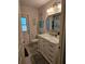 Well-lit bathroom featuring a marble vanity, decorative mirror, and patterned tile flooring at 3110 57Th Avenue E Cir, Bradenton, FL 34203