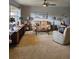 Comfortable living room with plush carpeting, large window, and modern ceiling fan at 3110 57Th Avenue E Cir, Bradenton, FL 34203