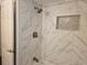 Beautiful shower with white marble tile, modern fixtures and a convenient inset shelf at 3110 57Th Avenue E Cir, Bradenton, FL 34203