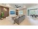 Stylish living room with modern decor, a gray sofa, and a tray ceiling with a fan, perfect for relaxation at 3129 61St E Ter, Ellenton, FL 34222