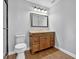 Bathroom featuring wood vanity with granite countertop, four-light fixture, and wood-look flooring at 3320 19Th Street E Ct, Bradenton, FL 34208