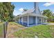 Charming blue home features a metal roof, wrap-around porch, and neat landscaping at 3320 19Th Street E Ct, Bradenton, FL 34208