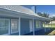 Charming blue home with metal roof, front porch and blue deck under a sunny blue sky at 3320 19Th Street E Ct, Bradenton, FL 34208