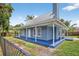 Charming blue home with a metal roof and a spacious, inviting wrap-around porch at 3320 19Th Street E Ct, Bradenton, FL 34208