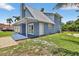 Side view of a charming blue house features a metal roof, porch, and well-maintained lawn at 3320 19Th Street E Ct, Bradenton, FL 34208
