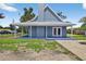 Blue home with a metal roof and cozy, covered porch, and well maintained lawn at 3320 19Th Street E Ct, Bradenton, FL 34208