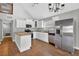 A bright kitchen featuring white cabinets, stainless steel appliances, and a wood grain tile floor at 3320 19Th Street E Ct, Bradenton, FL 34208