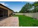 Green backyard with patio, screened-in porch, and white fence at 3712 76Th E St, Palmetto, FL 34221