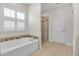 Bathroom features a tub with decorative tile, a glass enclosed shower and a window with shutters at 3712 76Th E St, Palmetto, FL 34221