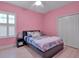 Pink bedroom with shuttered window, closet and light wood floors at 3712 76Th E St, Palmetto, FL 34221