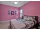 Bright bedroom featuring a ceiling fan and a large bed with decorative pillows and pink accent wall at 3712 76Th E St, Palmetto, FL 34221